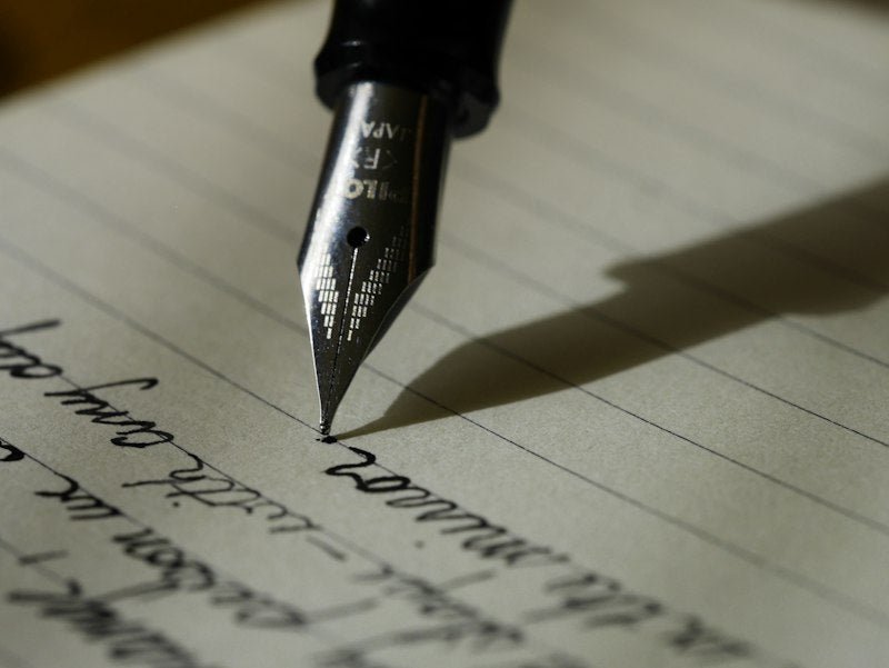Hand schrijft in notitieboek bij kaars, 369-methode uitgelegd