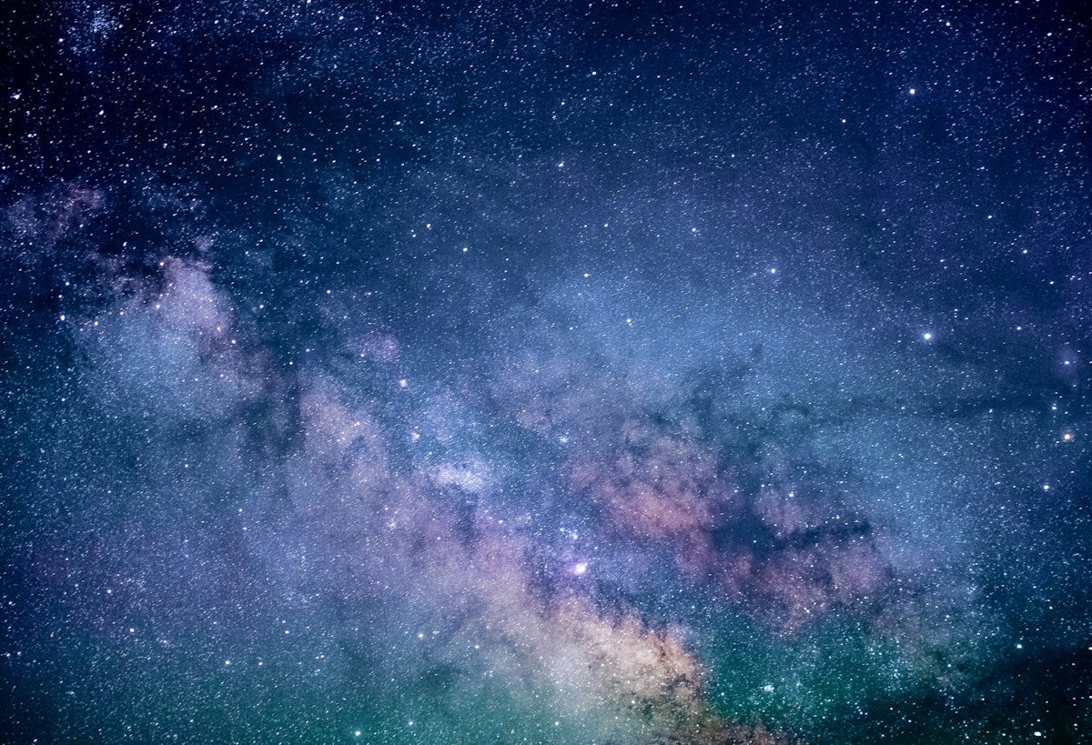 Sterrenhemel boven een rustig landschap als metafoor voor verbinding met het universum