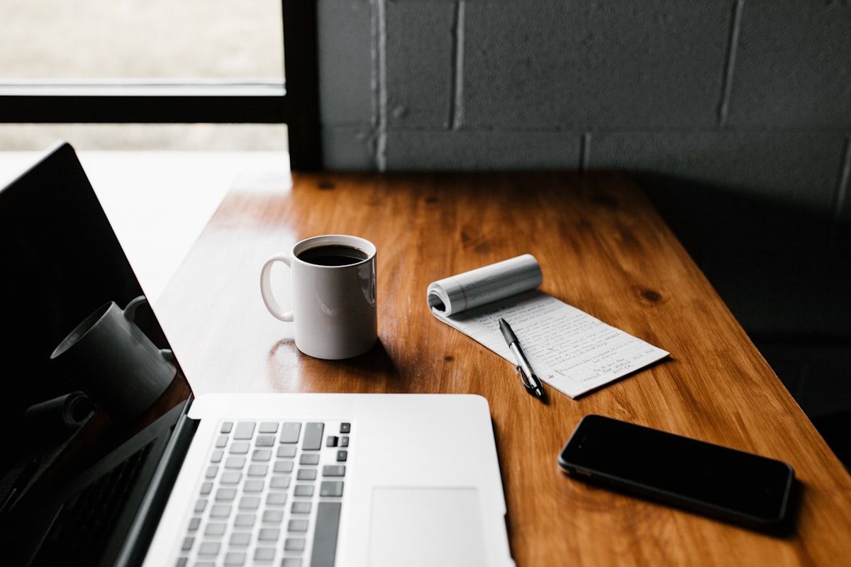 Bureau met notitieboek en laptop als metafoor voor diepe focus en geconcentreerd werken