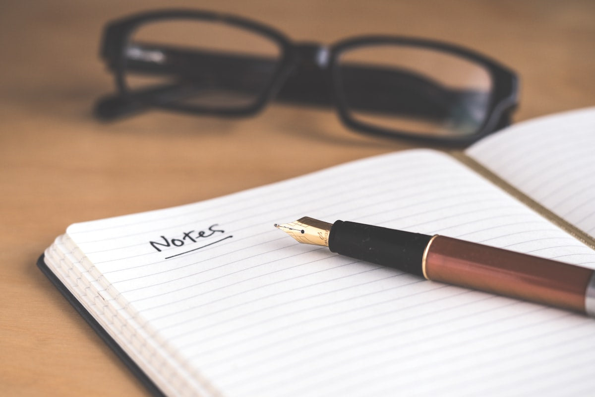 Hand schrijft in notitieboek als metafoor voor scripting en manifestatie via schrijven
